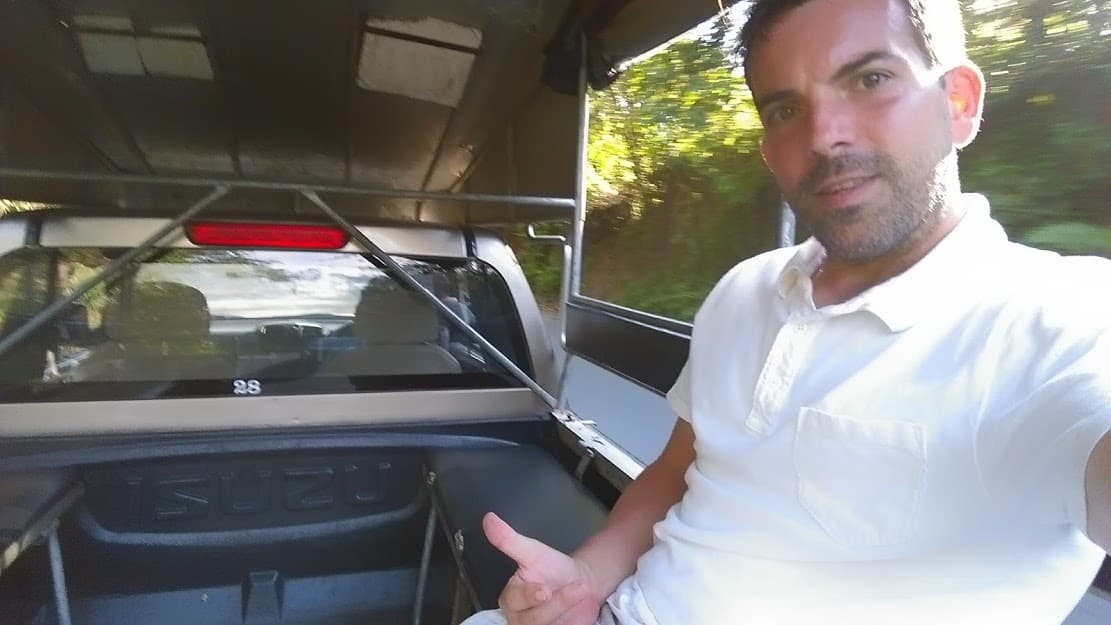 Eric Gamble hitch hiking in the back of a Truck in Phuket, Thailand